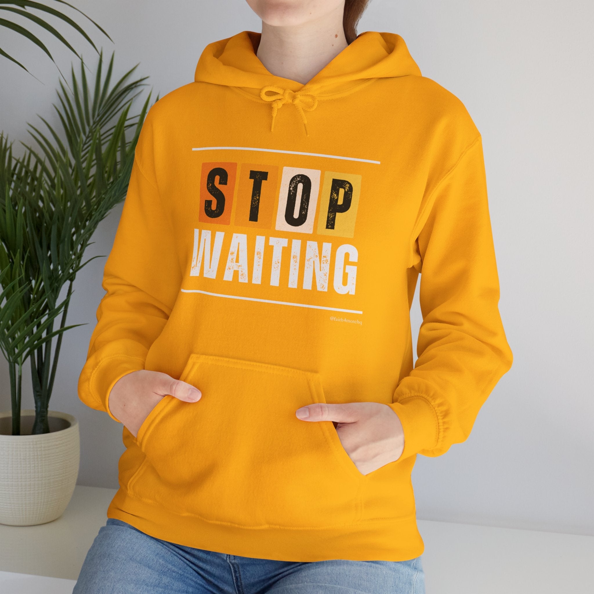 Unisex gold hooded sweatshirt with in bold “STOP WAITING” in black and white print